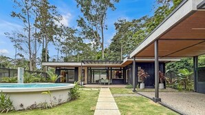 A modern house with a swimming pool, a covered patio, and a garden. - A Secluded Modern Villa with Private Pool, Jungle Oasis Bathtub & Beach Access (puerto viejo de talamanca)