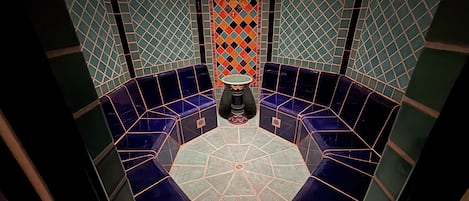 A circular seating area with a central table, surrounded by a patterned wall.