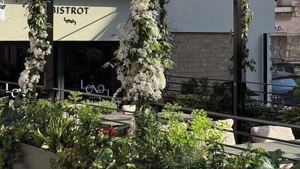 Un edificio con fachada de vidrio, sección de ladrillo y un letrero que dice 'BISTROT'.