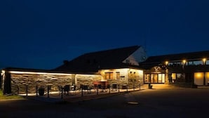 A building with a stone facade, a covered outdoor seating area, and a visible entrance. - Rondablikk (Nord-Fron)