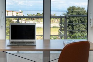 Ein Laptop auf einem Tisch mit Blick auf einen Balkon und das Meer.