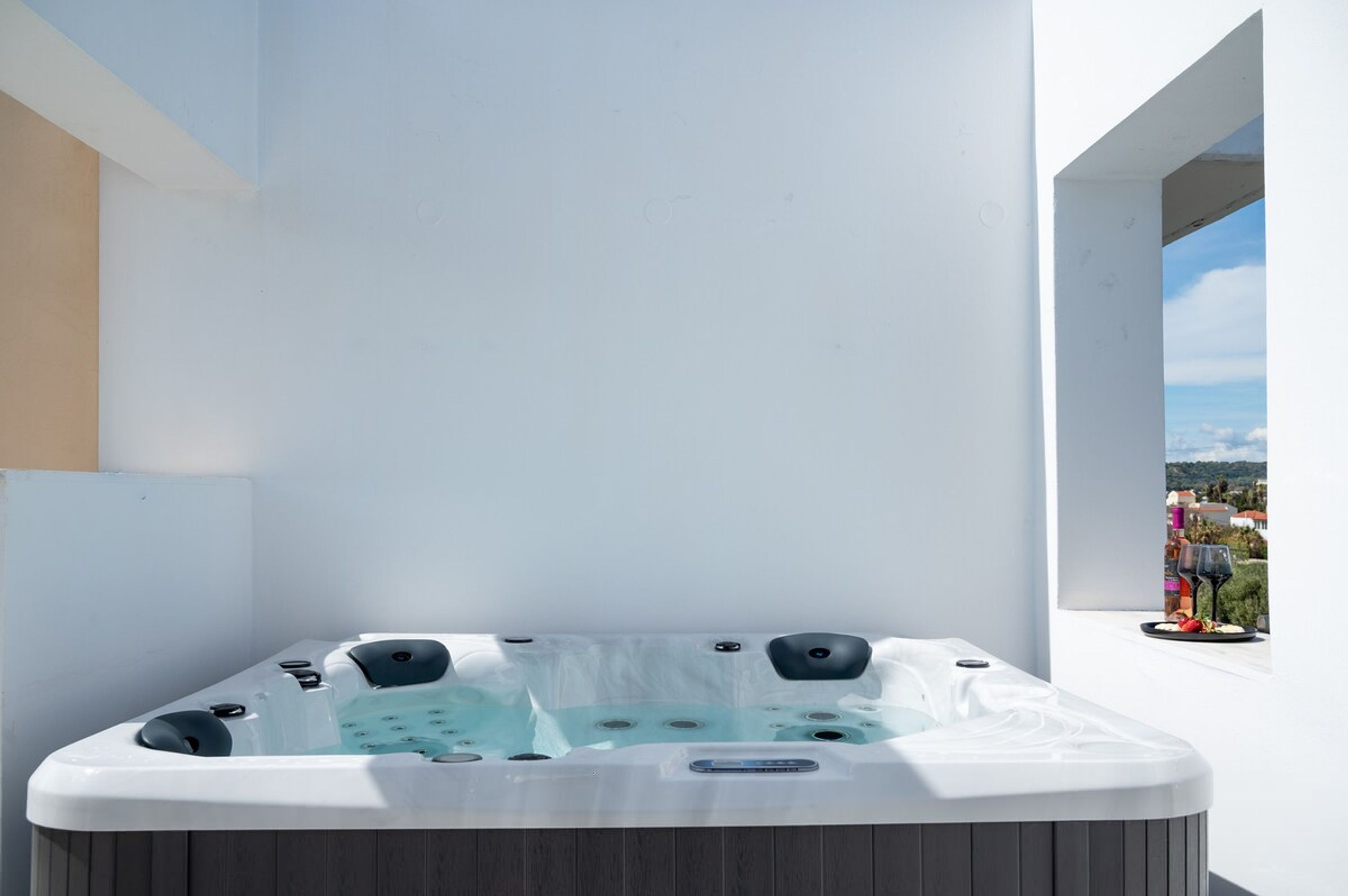 A hot tub on a balcony with a clear view of the cityscape.