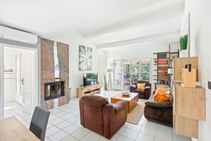 Un salon moderne avec une cheminée, un canapé, une table basse et une bibliothèque.