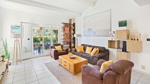 A spacious living room with a sofa, armchairs, a coffee table, and a bookshelf. - Sea View | Quiet & Green | 8 People | Air Conditioning & BBQ (Hyères)