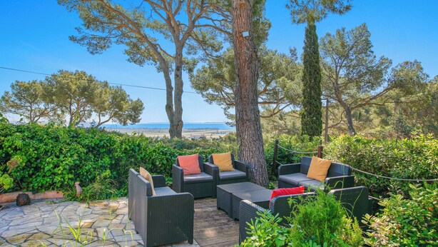 An outdoor seating area with wicker furniture and a view of the sea. - Sea View | Quiet & Green | 8 People | Air Conditioning & BBQ (Hyères)