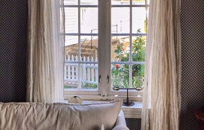 A room with a window, a white fence, and a potted plant outside. - 2 bedroom awesome home in Farsund (Farsund)
