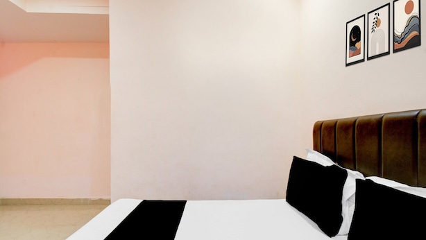A hotel room with a bed, a headboard, and three framed artworks on the wall. - Deluxe Hotel Nakshatra (Patancheruvu)