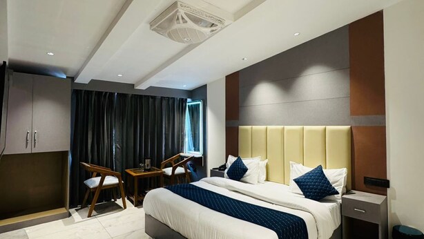 A modern hotel room with a large bed, a desk, and a chair. - The Moonsoon Inn (Mussoorie)