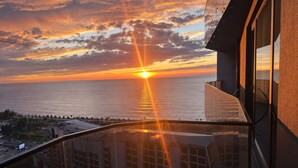 A sunset view from a balcony overlooking a body of water, with buildings in the foreground. - Opus Batumi (Batumi)