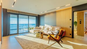 A modern living room with a large window, a sofa, a coffee table, and a chair. - Opus Batumi (Batumi)