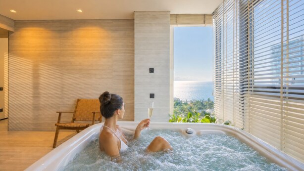 A woman in a hot tub with a glass of wine, wooden walls, and a view of greenery. - Opus Batumi (Batumi)