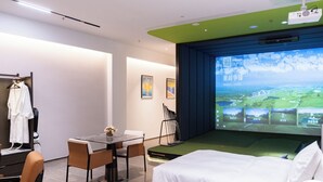 A hotel room with a bed, a desk with a chair, a TV screen displaying a landscape, and a coat rack with a robe. - Golf Suite Hotel (Shenzhen)