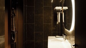 A modern bathroom with a geometric patterned floor, a large mirror, and a standalone sink. - Golf Suite Hotel (Shenzhen)