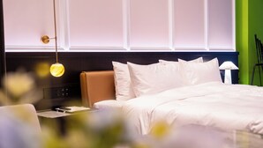 A hotel room with a bed, bedside table, and a lamp. - Golf Suite Hotel (Shenzhen)