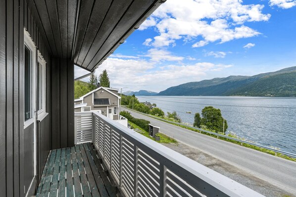 A balcony with a view of a lake and mountains.