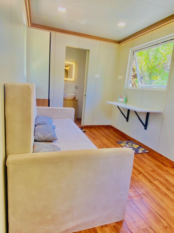 Une chambre à coucher comprenant un lit, une table de chevet, une fenêtre avec vue et une porte donnant sur une salle de bain.