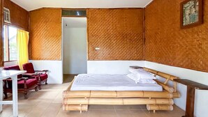 A room with a bed, a desk, and a chair. - Cozzy HEPI Bungalo Lovina Singaraja Bali (Buleleng)