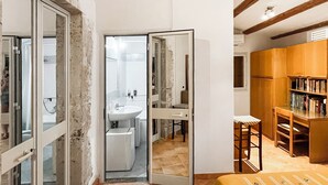 Une chambre à coucher avec un lit, un bureau en bois, une chaise et une bibliothèque.