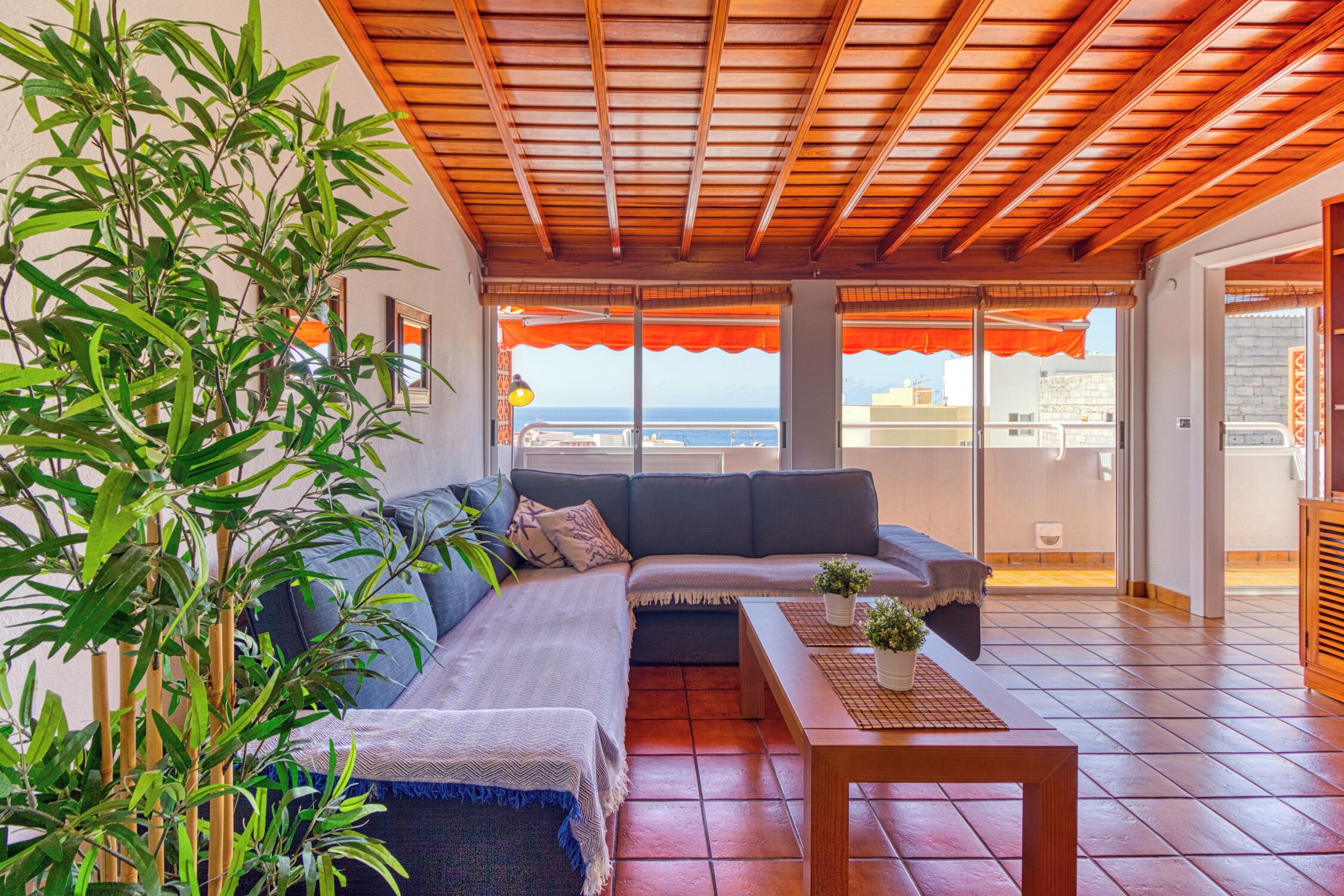 Ein Wohnzimmer mit einer Couch, einem Couchtisch und Meerblick durch große Fenster.