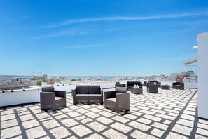 A rooftop terrace with outdoor seating and a cityscape view. - Double Room with Private Balcony and Sea View (Porto Cesareo)