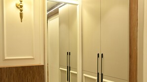 A bathroom with a mirror, vanity, and a wooden bench. - ANANTA KASHI HOTEL (Varanasi)