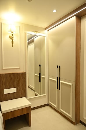 A bathroom with a mirror, vanity, and a wooden bench. - ANANTA KASHI HOTEL (Varanasi)