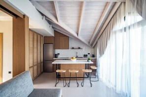 A modern kitchen with a central island, wooden cabinets, and a built-in refrigerator.