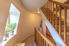 A staircase with wooden railings, carpeted steps, and a white wall. - Hadley Park Windmill (Telford)