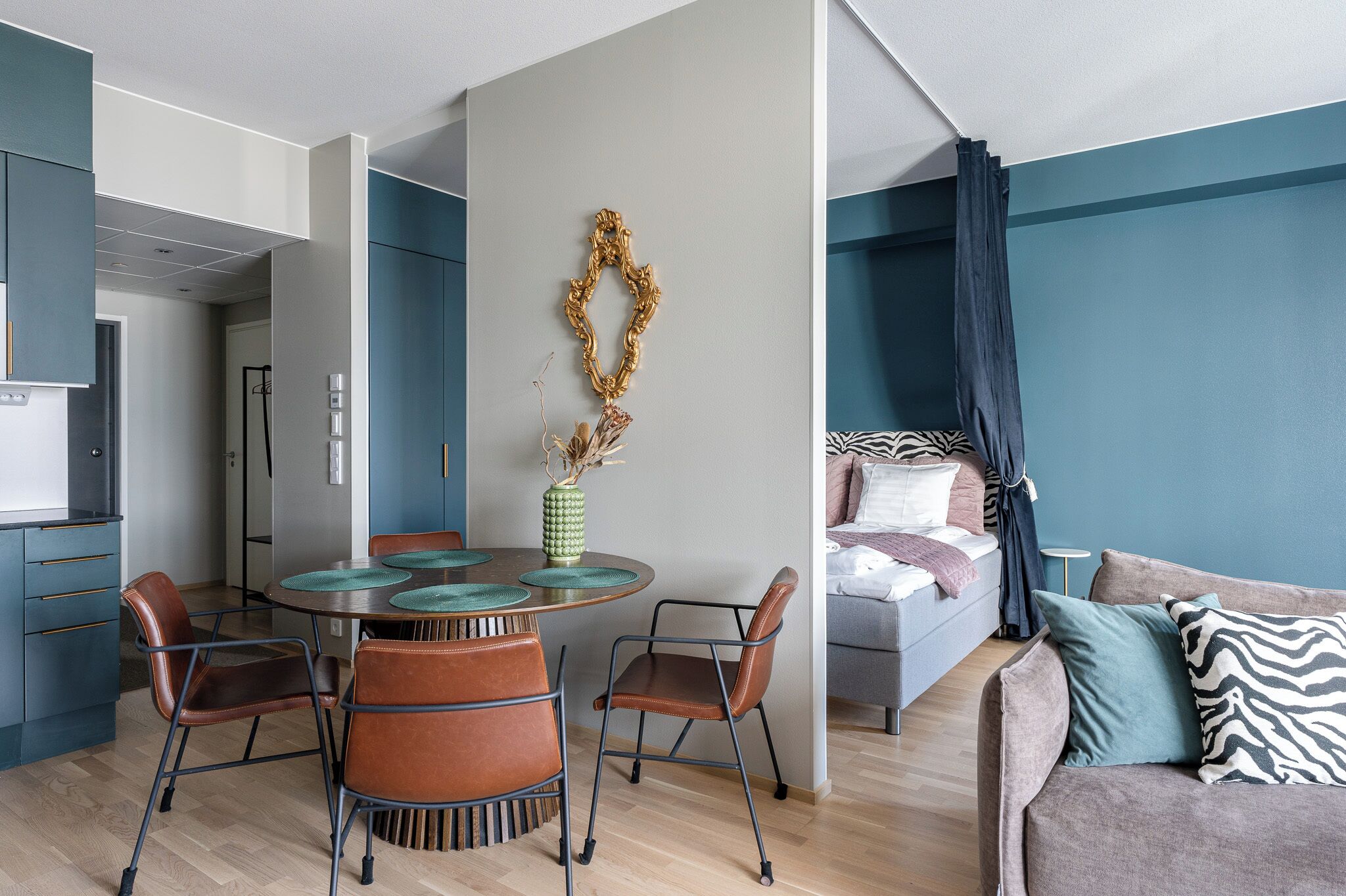 Un salon moderne comprenant un canapé, une table à manger avec des chaises, un coin cuisine et une chambre avec un lit.