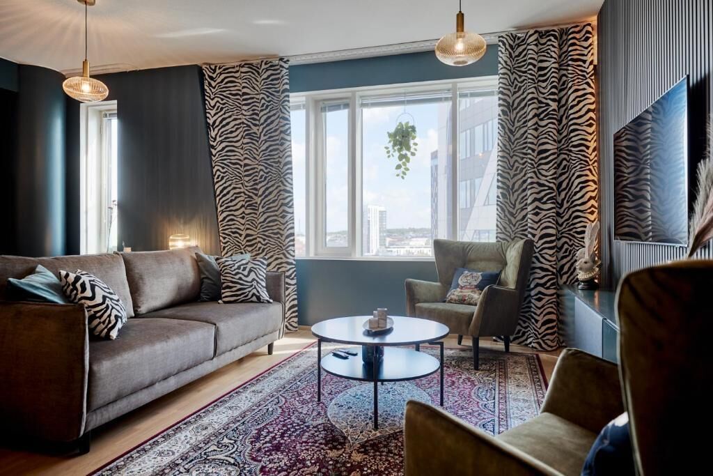 A modern living room with a sofa, armchair, and round coffee table.