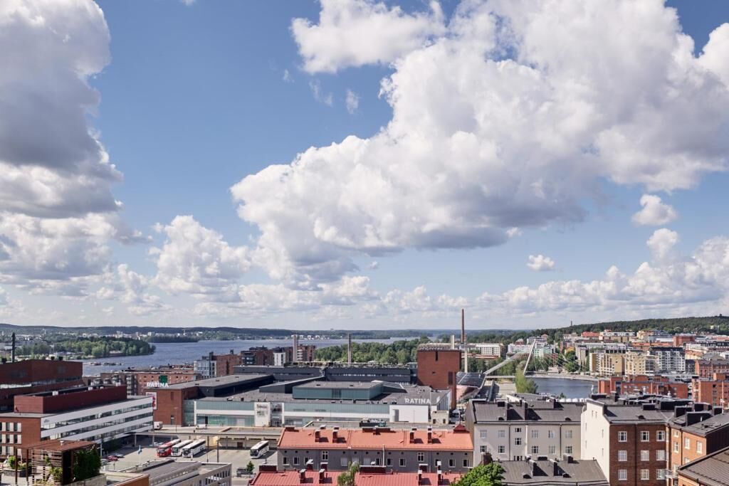 A cityscape with industrial buildings, a river, and a bridge.