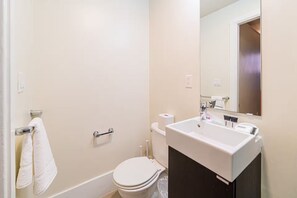 Ein kleines Badezimmer mit Toilette, Waschbecken und Spiegel.