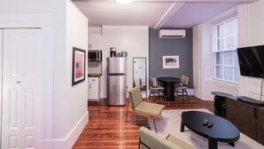 Espaço compacto com cozinha compacta, área de refeições e sala de estar com televisão.