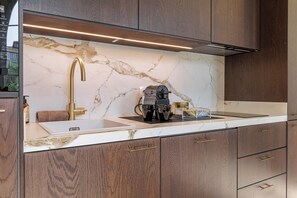 A modern kitchen with marble backsplash, wooden cabinets, and stainless steel appliances. - Exceptional apartment in the heart of Nice (Nice)