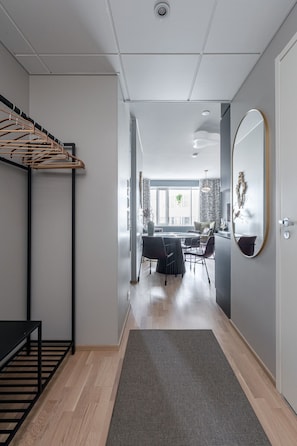 Ein modernes Interieur mit einer Holzbank, einem Essbereich mit runden Tischen und einem großen Spiegel an der Wand.