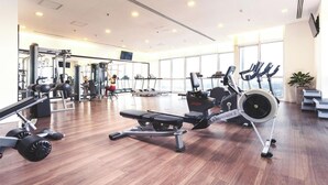 A spacious gym with various exercise equipment, large windows, and a clean, modern design. - City Centre Apartment - Lancaster Hanoi (Hanoi)