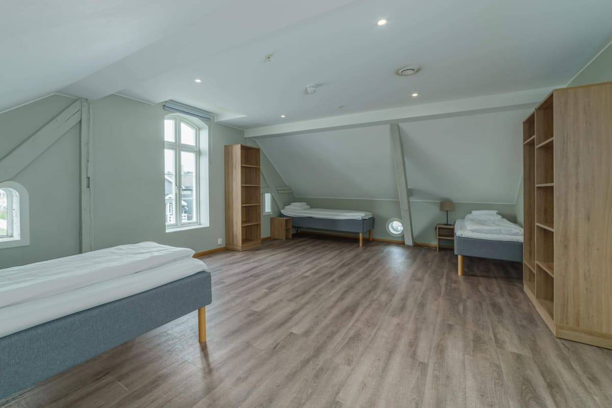 Quarto com cama beliche, escrivaninha e guarda-roupa.