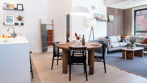 Uma sala moderna com área de jantar, um conjunto de sofás e uma mesa de centro.