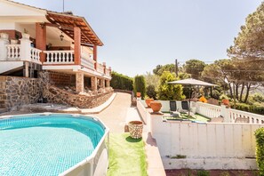 A pool, a patio with outdoor furniture, and a house with a balcony. - Holiday Home 'Villa Toro' with Mountain Views, Wi-Fi and Air Conditioning (Maçanet de la Selva)