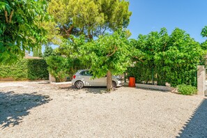 A car parked in a gravel driveway with trees and a hedge in the background. - Apartment 'Appt Saint Remy De Provence' with Private Terrace and Wi-Fi (Saint-Étienne)