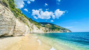 A coastal beach with white cliffs, clear turquoise water, and a clear sky. - Residence Mattinatella - Apartment 2 (Mattinata)