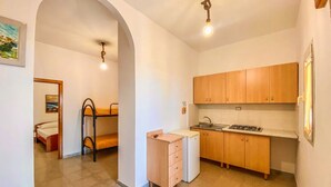 A compact room with a bunk bed, kitchenette, and a small bathroom. - Residence Mattinatella - Apartment 2 (Mattinata)