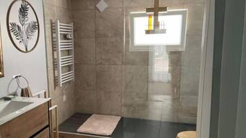 Een douche, handdoeken, zeep, toiletpapier