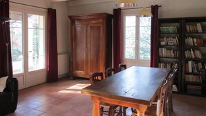 A dining area with a wooden table and chairs, a cabinet, and a bookshelf. - VAISON LA ROMAINE QUIET LITTLE HOUSE IN THE COUNTRYSIDE (Crestet)