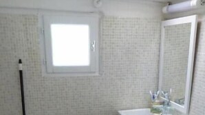 A bathroom with a toilet, sink, and window. - Small house in the heart of the Cévennes (Concoules)