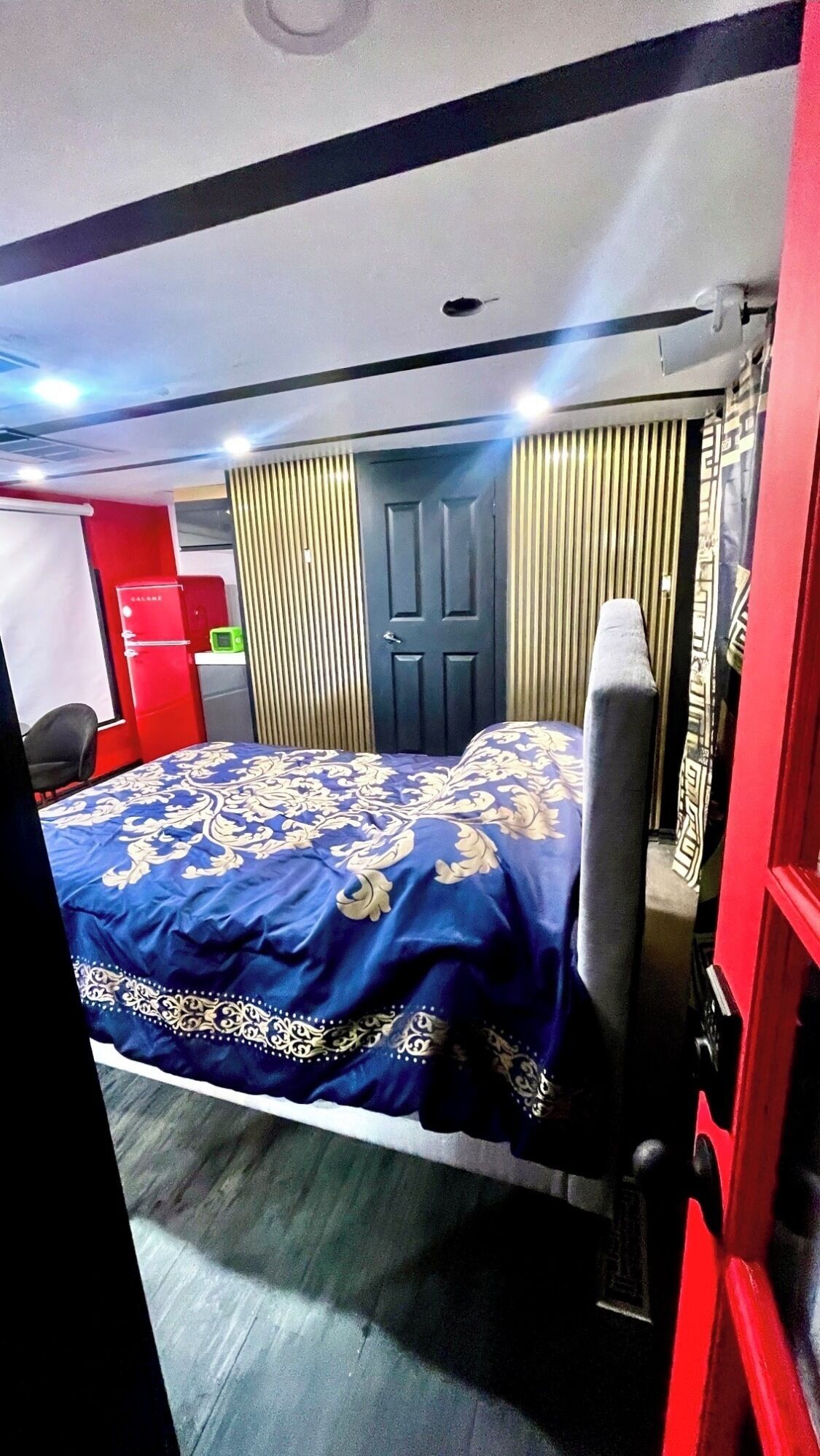 Una habitación de hotel con una cama, un escritorio, un armario y una puerta.