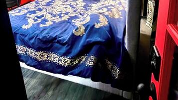Una habitación de hotel con una cama, un escritorio, un armario y una puerta.