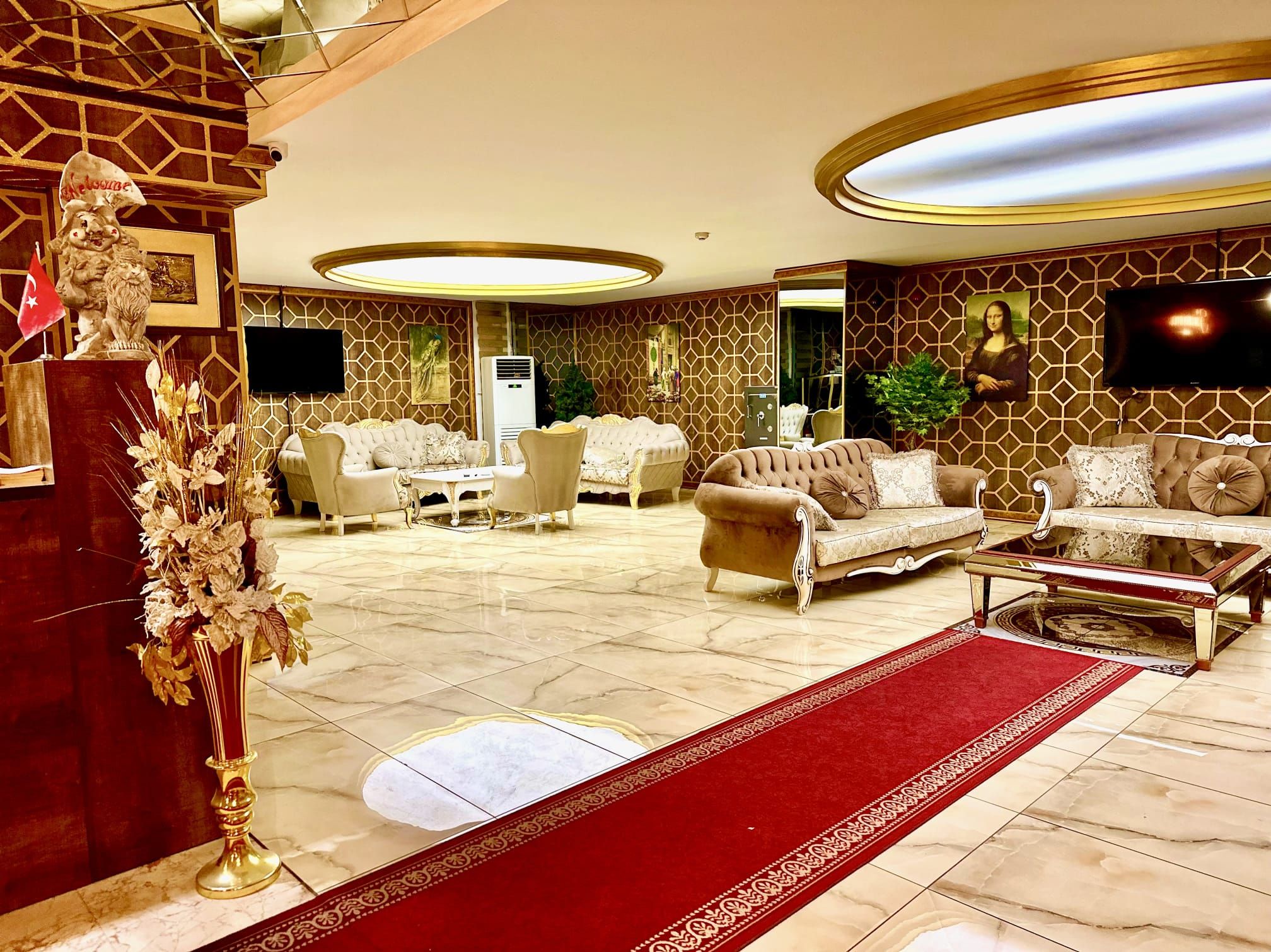 Un salón lujoso con alfombra roja, muebles elegantes y un cuadro grande en la pared.