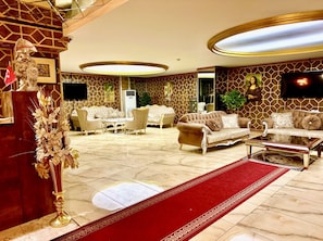 A luxurious living room with a red carpet, elegant furniture, and a large painting on the wall. - AY HANEDAN HOTEL (Osmangazi /bursa)