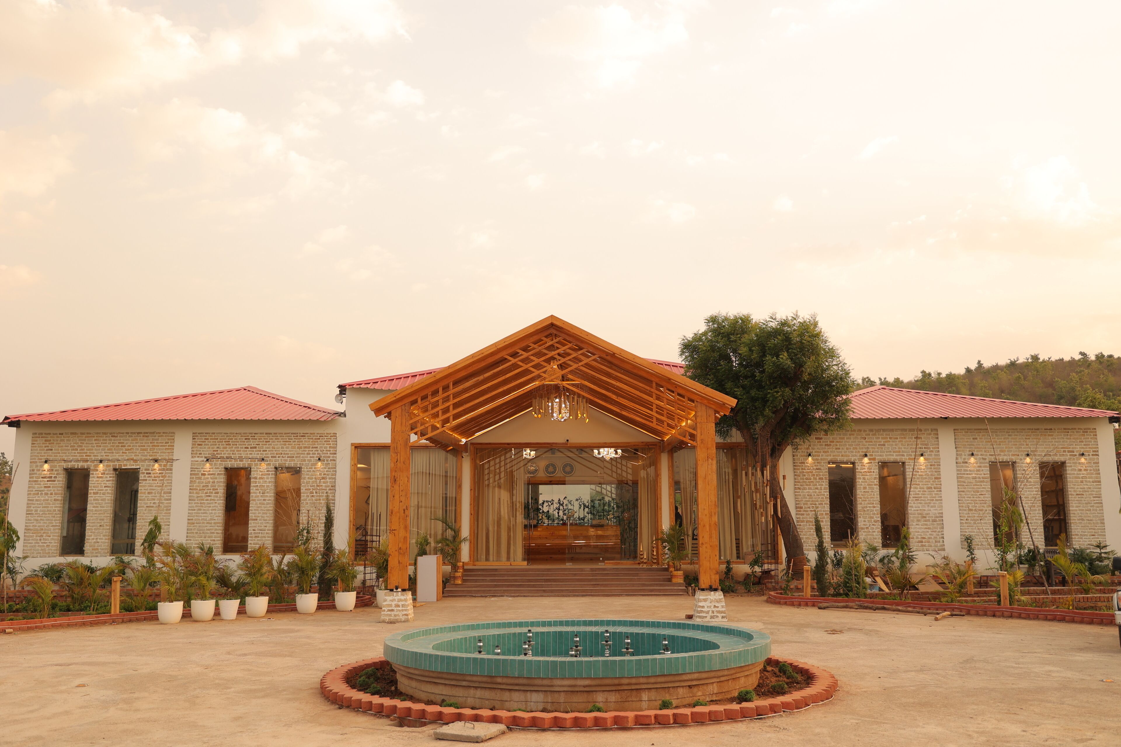 A building with a covered entrance, a central fountain, and a landscaped garden.